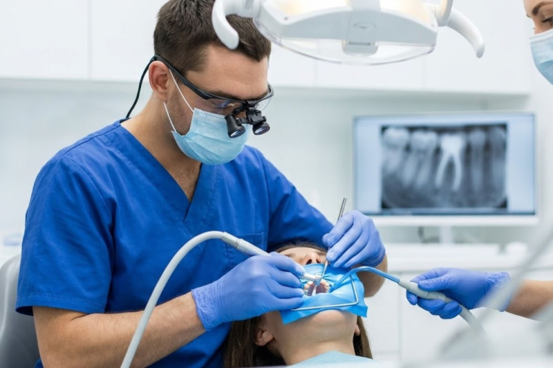 A dentist performing root canal treatment in Mount Vernon clinic showing procedure and patient care.